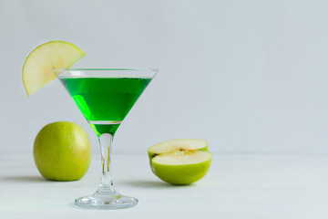 Apple cocktail mixed drink with vodka and apple slice. Apple martini cocktail on the white background. Homemade Green Alcoholic drinks in martini glasses with apple slice. copy space.