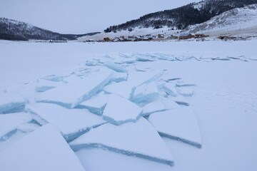 Fototapeta na wymiar Estructuras de hielo congeladas y placas rotas al amanecer sobre lago helado