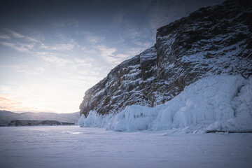 Fototapeta na wymiar Estructuras de hielo congeladas y placas rotas al amanecer sobre lago helado