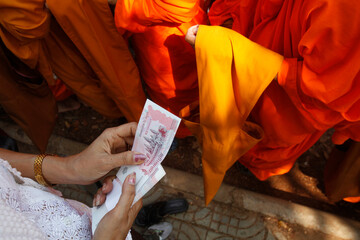 Woman giving alms to monks on Meak Bochea (Makha Bucha) holiday