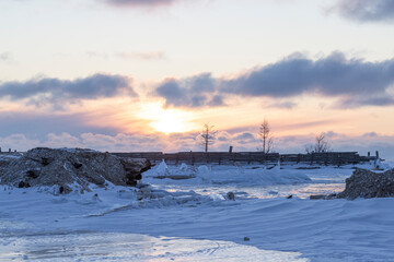 Viejo dique congelado al amanecer sobre lago helado