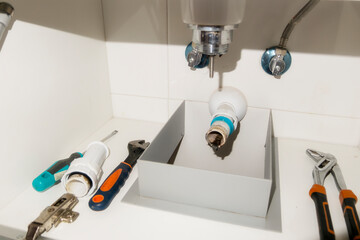 dirty and clogged pipes under the sink with plumbing tools. Plumbing and maintenance and home...
