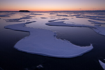 Placas de hielo rotas congeladas al amanecer sobre lago helado
