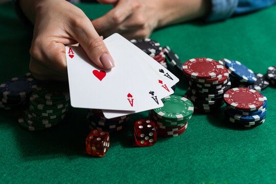 A woman plays in a casino. opening cards to raise bets. Against the background of chips. Poker victory