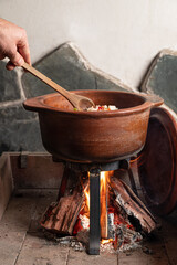 cocinando con leña en olla de barro tradicional Argentina