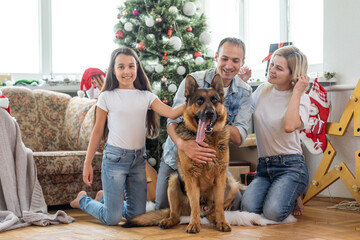 happy family and cute dog having fun at christmas tree. atmospheric emotional moments. merry christmas and happy new year concept.