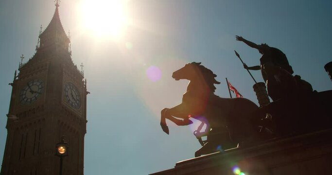 Big Ben, Houses of Parliament, Union Jack flag and Boadicea or Boudica statue on Westminster Bridge, London, England