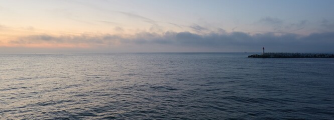 Baltic sea at sunset. Dramatic sky, blue and pink glowing clouds, soft golden sunlight, midnight...