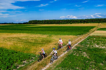 happy family on bike ride outdoors. Happy mother father and kids on bikes cycling outdoors. active family sport and fitness together. drone photo