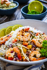 Spaghetti with prawns and parmesan on wooden table
