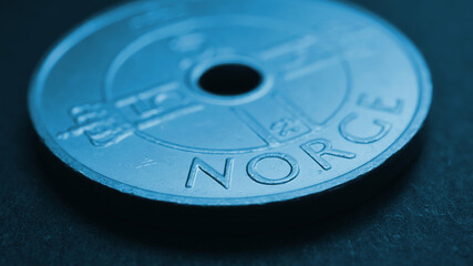 Translation: Norway. 1 Norwegian krone coin closeup. National currency of Norway. Blue tinted money wallpaper about economy or finance. Bank and loan. Savings and interest. Kroner and Norges Bank