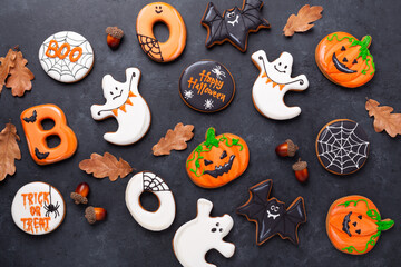 Halloween gingerbread cookies on dark stone background. Bright homemade cookies for Halloween party