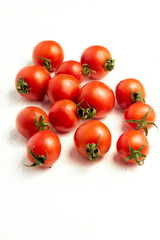 Group of cherry tomatoes, ripe organic tomatoes on a light background, vertical photo