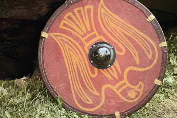 Red vintage shield with with the phoenix bird a medieval warrior. Reconstruction of the events of the Middle Ages in Europe