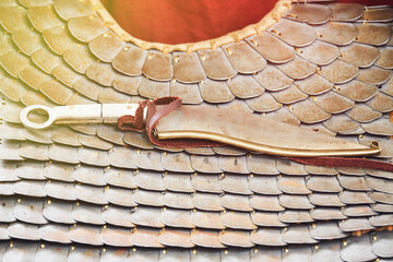 Ancient Roman retro chain mail made of metal plates and a dagger in a sheath, vintage scaly armor...