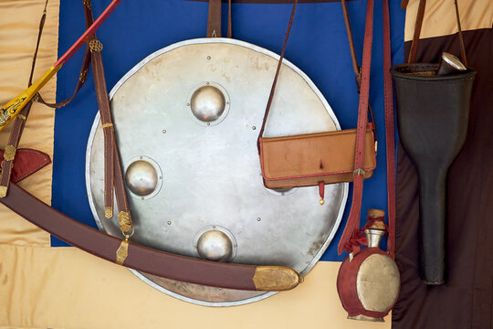 Vintage bow, arrows in a quiver and a retro shild on the background of the Swedish flag. Ancient military arsenal of the events of the Russian-Swedish war
