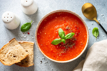 Tomato soup on light stone table. Vegan dish. Top view on light stone table.