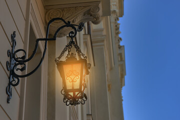 Fototapeta na wymiar Beautiful old fashioned street lamp lighting on wall of building
