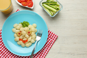 Tasty pasta served with vegetables on wooden table, flat lay. Creative idea for kid lunch