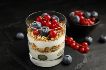 Delicious yogurt parfait with fresh berries on black table, closeup
