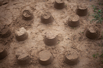 Sand cakes in sandbox. Lot of objects made from stove. Result of children's play.