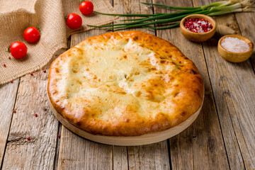 Ossetian pie with spinach on old wooden table