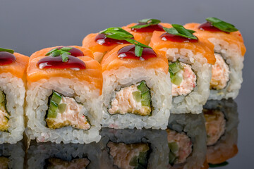roll with baked salmon and fresh salmon on black with reflection