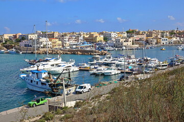 View of the village overlooking the old port of Lampedusa. LAMPEDUSA, ITALY - AUGUST, 2019 - obrazy, fototapety, plakaty