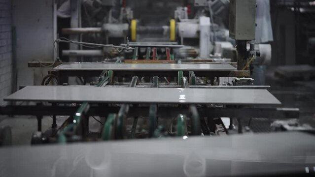 Factory for the production of ceramic tiles and porcelain tiles. Automatic conveyor in the workshop.