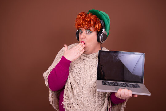 Drag queen watches horror movies on laptop.	