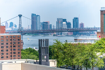 Fototapeta na wymiar views of the Empire State Building and New York skyline seen from Brooklyn rooftop and also view of one world trade Williams burg bridge