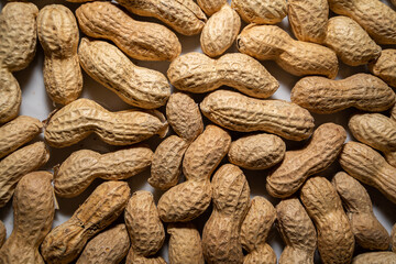 Background with many roasted and unpeeled peanuts in close up
