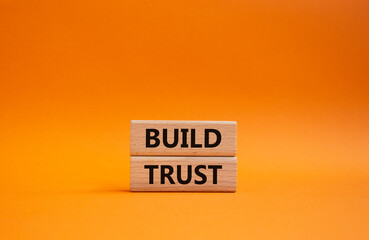 Build trust symbol. Wooden blocks with words Build trust. Beautiful orange background. Business and Build trust concept. Copy space.