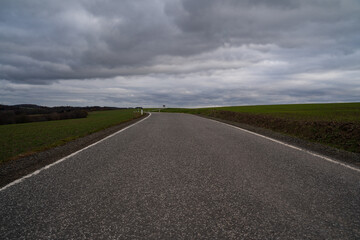 Rural road with cloudy sky in autumn 