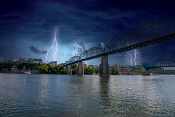 a shot of the Walnut Street Bridge over the rippling blue waters of the Tennessee River surrounded...
