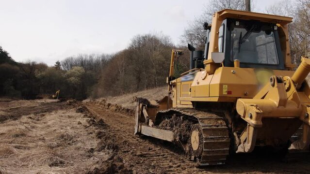 Construction machinery equipment, earth building bulldozer, earthmoving machine technology, industrial erection concept. Bulldozer working on mud at a construction site