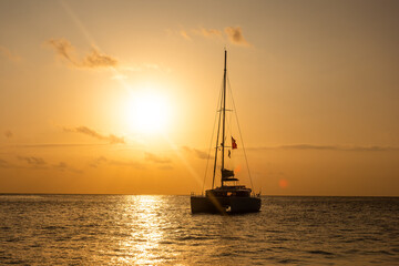 Sunset in the Indian Ocean. Silhouette of a sailing catamaran anchored against the backdrop of the...