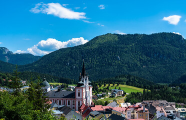 Beautiful aerial view of Mariazell town with Mariazell basilica on sunny summer day with the Alps and blue sky cloud, Styria, Austria - 516224265
