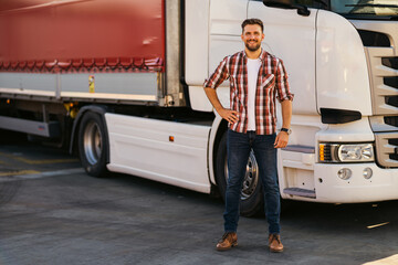 smiling handsome masculine driver stranding next to his white truck outside