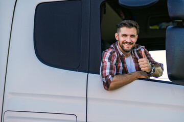 Truck driver sitting in his truck showing thumbs up. Trucker occupation. transportation services.