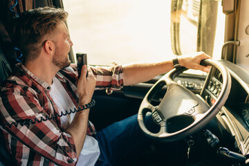 Fototapeta na wymiar Semi Truck Driver Making Conversation with Other Truck Drivers Through CB Radio.