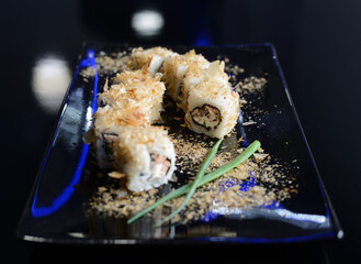 Sushi rolls on black dish. Japanese food.