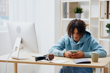 Fototapeta premium A young man sitting at a table in front of a computer freelance Lifestyle