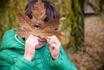 The boy looking through the hole heart-shaped in the maple leaf.