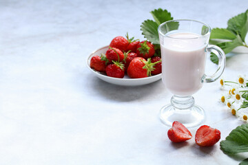 yogurt in a glass and strawberries on the table.