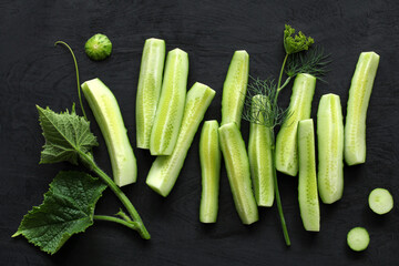 fresh cucumbers on a black background, top view.