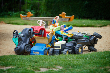 pile of children's toy cars on a playground