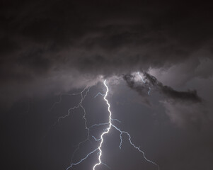 Fototapeta na wymiar big lightning bolt from dark cloudy storm sky