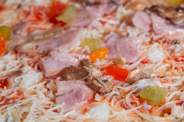 Uncooked pizza with with ham, mushroom, pepper, cheese in electric oven - close up view. Italian cuisine, homemade bakery, fast food, semi-finished products and raw concept