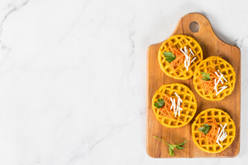 Snack carrot waffles on a wooden board. Light background. Top view. Copy space